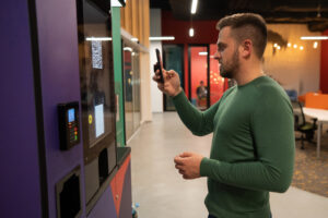Utilizzo di uno smartphone presso un distributore automatico: immagine di riferimento sui pagamenti digitali