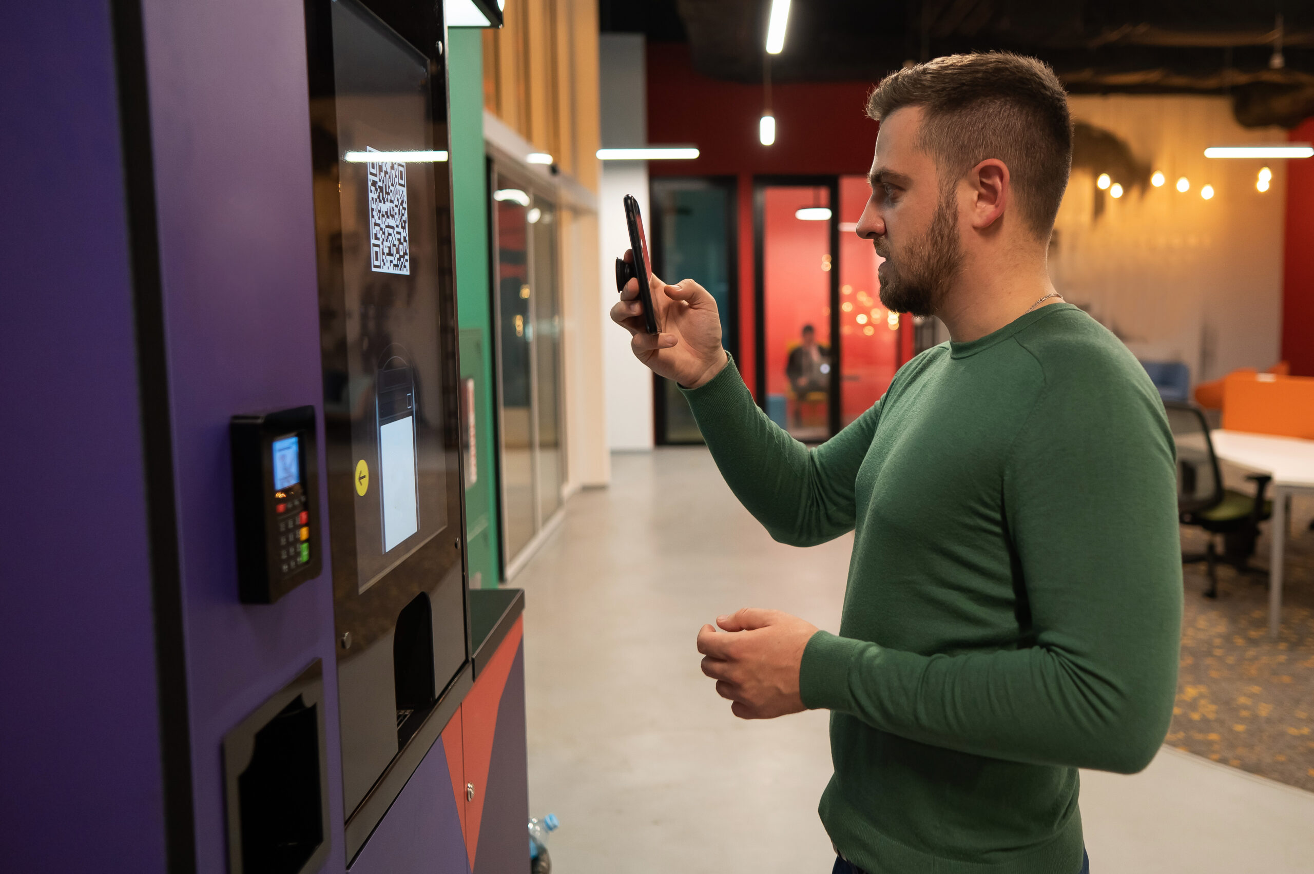 Utilizzo di uno smartphone presso un distributore automatico: immagine di riferimento sui pagamenti digitali