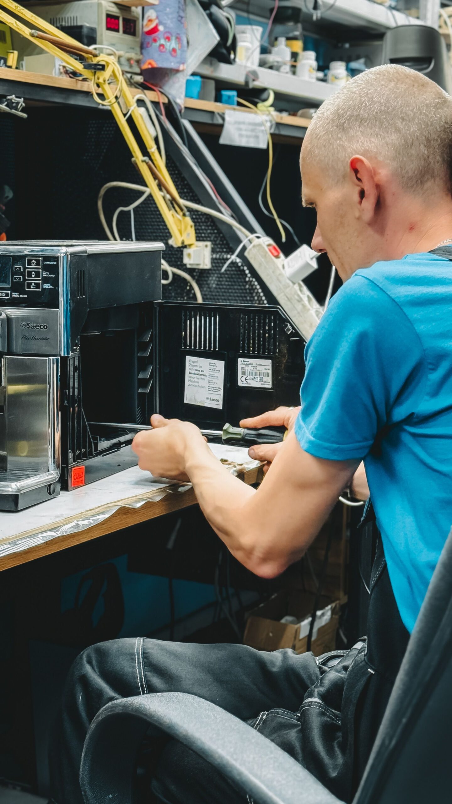 Tecnico al lavoro su una macchina da caffè in officina